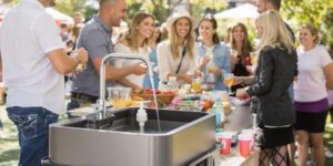 Portable sink at an outdoor event with happy guests.