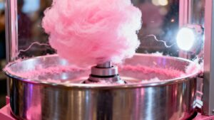 Commercial candy floss machine making pink candy floss.