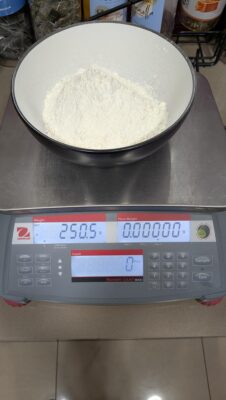 Weighing 250g of waffle mix flour on a scale before making batter for the Fracino MULTI