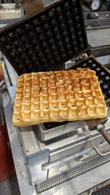 Crisp golden waffle lifting cleanly off the seasoned cast-iron plates of a Fracino MULTI LPG waffle machine